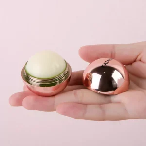 Open FATAZEN rose-gold round lip balm held in hand