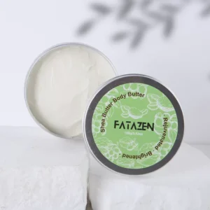 Open FATAZEN Shea Butter Body Butter jar on a light fabric surface
